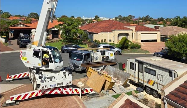 Crane lifting load-bearing beam into home.
